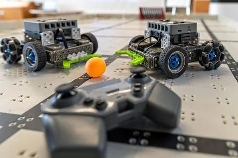 Robots compete on a technology-filled table in a playful game during a roboti Stock Photos