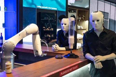 Robots in human form stand behind the bar Stock Photos