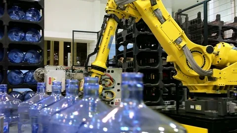 Robots loaders work in a warehouse. Water bottle conveyor industry. Stock Footage 71200954