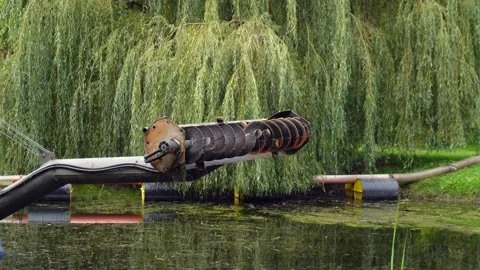 A robust mechanical device with pipes extends over the water surface. A lar.. Stock Footage 321918271