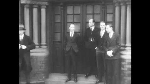 ROCHESTER - 1929 - A group of men stand beside a doorway with more men leaving Stock Footage 340589325