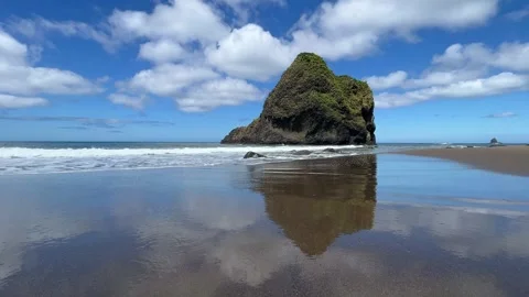Rock and clouds reflected in water on sandy beach, Hokkaido, Japan Stock Footage 247896617
