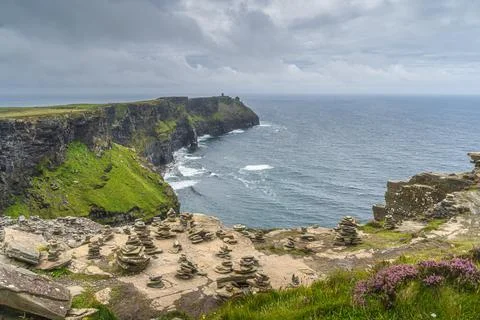 Rock balancing on the edge of iconic Cliffs of Moher, Ireland Stock Photos