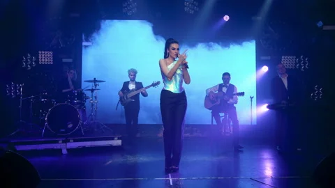 Rock band performs on stage with a light show Stock Footage 194548925