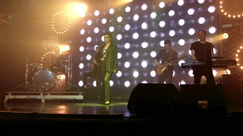 A rock band on stage begins a performance with a light show Stock Footage 194545595