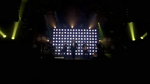 A rock band on stage begins a performance with a light show Stock Footage 194545700