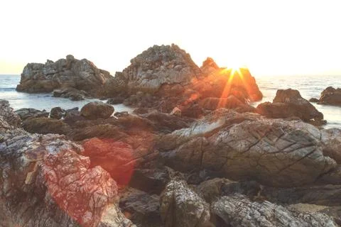 Rock on the beach with sunset Stock Photos