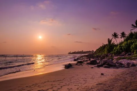 Rock beach at sunset Stock Photos
