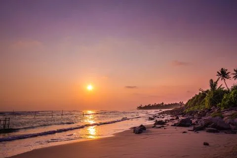 Rock beach at sunset Stock Photos