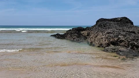 Rock on beach with waves on a summers day Stock Footage 274935168