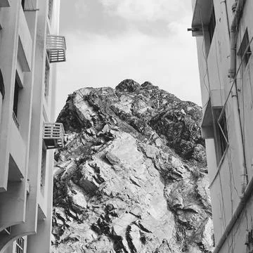 A rock between two high-rise buildings. Landscapes of Oman. Muscat. Black and Stock Photos