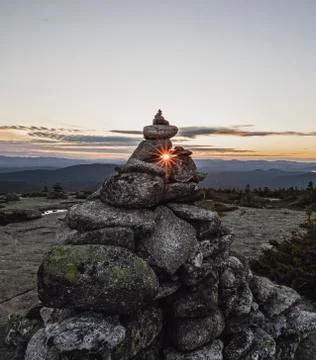 Rock cairn frames setting sun on summit of Baldpate Mountain, Maine Stock Photos