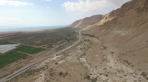 Rock cliff facing agriculture fields and the Dead sea in the Desert  Video stock 68342550