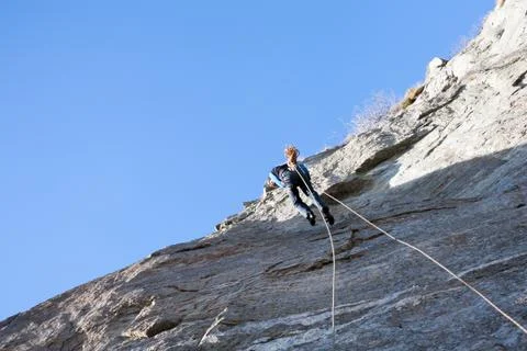 A rock climber abseiling off a climb Stock Photos