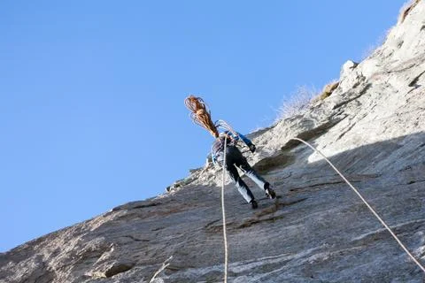 A rock climber abseiling off a climb Stock Photos