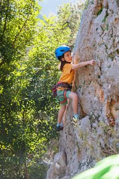 Rock climber boy. child is practicing rock climbing. summer camp. sport in na Stock Photos