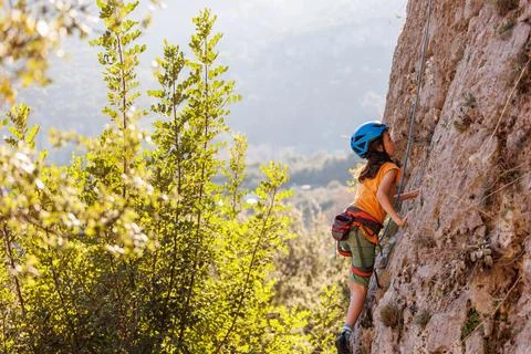 Rock climber boy. child is practicing rock climbing. summer camp. sport in na Stock Photos