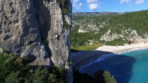 Rock climber on the cliffs of Greece with Sea in background 180 degree Aerial  Stock Footage 73849682