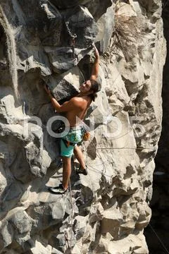 Rock Climber Climbing Up A Cliff Stock Photos