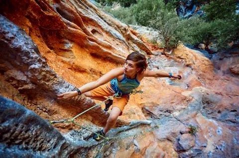 Rock climber climbing up a cliff Stock Photos
