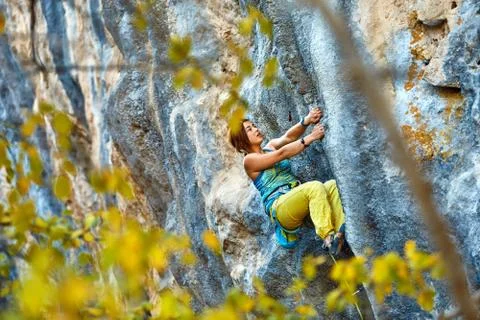 Rock climber climbing up a cliff Stock Photos