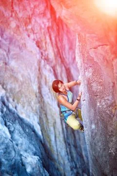 Rock climber climbing up a cliff Stock Photos