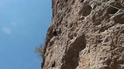 Rock Climber Climbing a Sheer Cliff Stock Footage