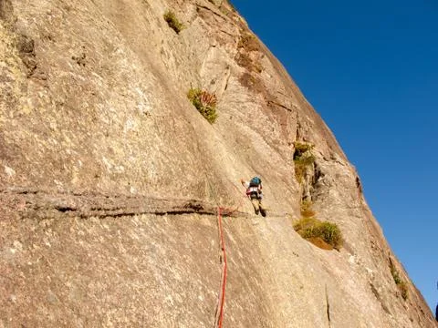 Rock climber climbing a sloping rock wall in Brazil Stock Photos