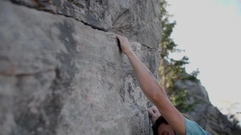 Rock climber climbs up boulder in boulder field 库存影片 220306119