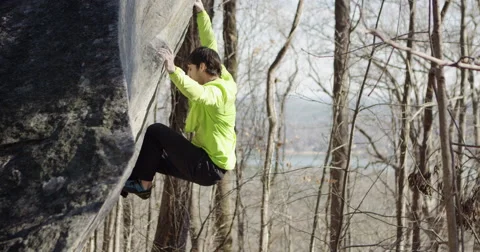 Rock climber does a hard move lake in background Slow motion 4K Stock Footage 50937090
