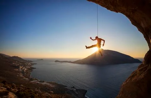 Rock climber hanging on rope while lead climbing Stock Photos