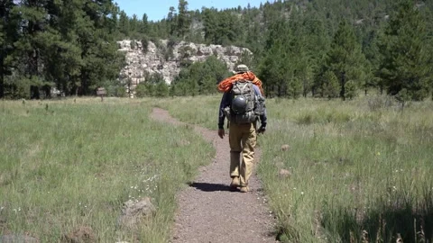A rock climber heading for the cliffs with rope and gear Stock Footage 249119718