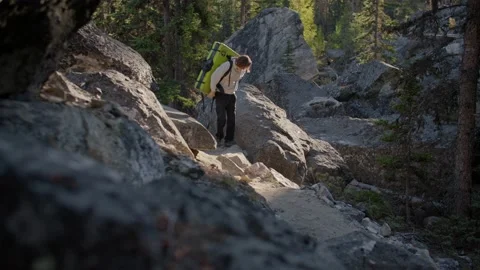 Rock climber puts crash pad on back in boulder field 库存影片 220305906