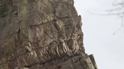 Rock climber rappelling down mountain in Colorado Stock Footage 76413378