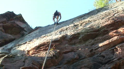 Rock climber rappelling Stock Footage