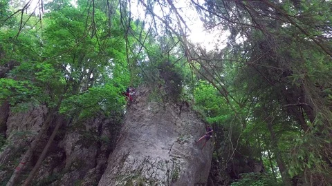 Rock climbers rappelling in a mountain forest on summer day Stock Footage 72840434