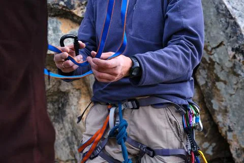 Rock climbing instructor is teaching how to perform the belay station. Stock Photos
