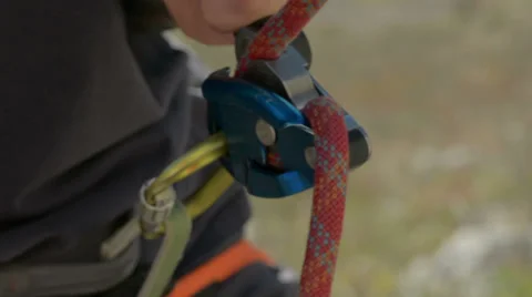 Rock climbing rope passes through belay device HD Video stock 33531369