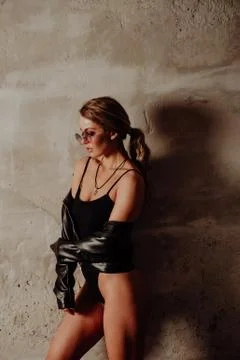 Rock concept. Portrait of charming blond woman in black bodysuit and leather  写真素材