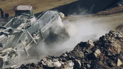 Rock crushing machine and bulldozer operator at work in quarry, slow motion Video stock 294101585