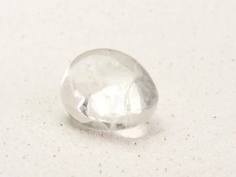 Rock crystal gemstone rotating on white sand Stock Footage 73023790