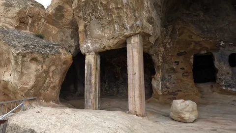 Rock-cut chambers open beneath carved sandstone ceilings at Uplistsikhe Stock Footage 340385958