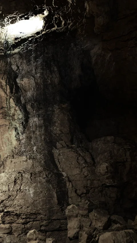 Rock formation inside a cave with light shining from an opening above Stock Footage 331748879