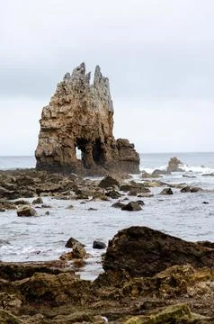 Rock formation in the sea with dramatic cliffs on a cloudy day, natural coa.. Stock Photos