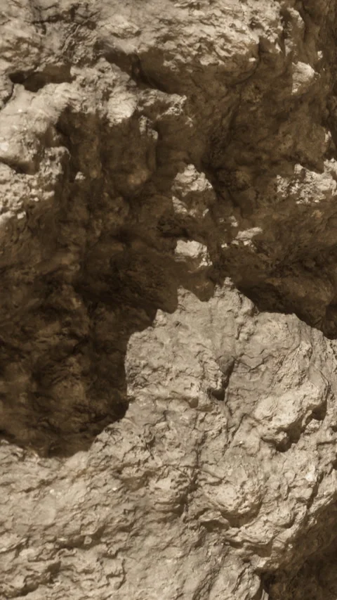 Rock formation shows texture and detail in sunlight on mountain side Stock Footage 339397022