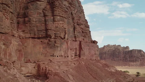 Rock formation with sun, clouds, blue sky. AlUla, Saudi Arabia. Aerial 4K. Stock Footage 196825092