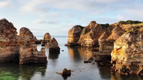 Rock formations and clear waters of Algarve in Portugal at sunset Stock Footage 313284739