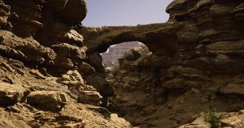Rock formations create a natural arch in a desert canyon after sunset Stock Illustration