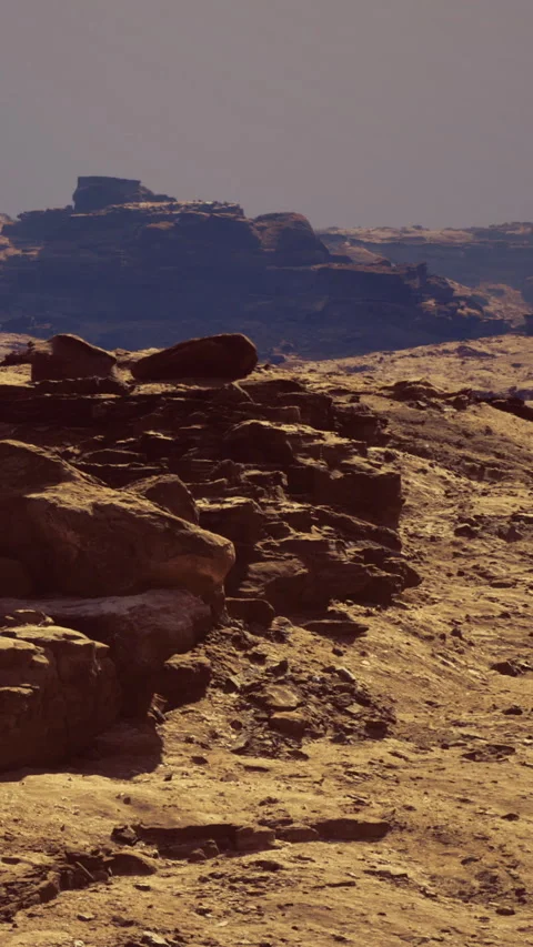 Rock formations on a landscape during daylight near a distant mountain range Vídeo Stock 342445976