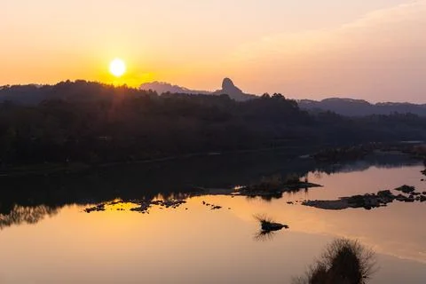 Rock formations lining around the river in Wuyishan during the sunset Stock Photos